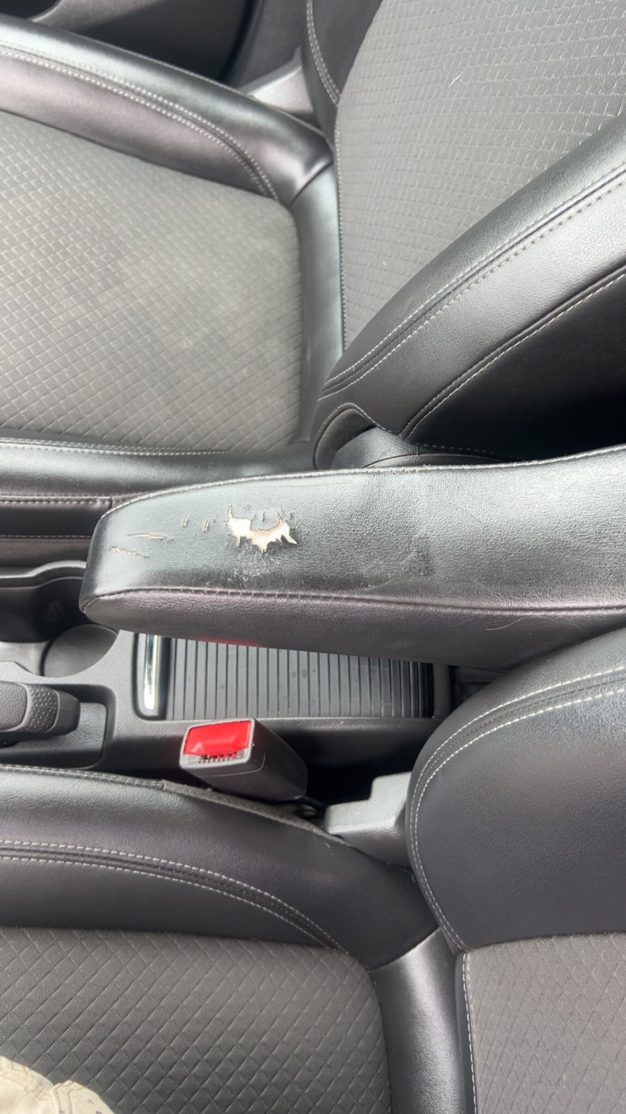 Torn center console armrest before repair