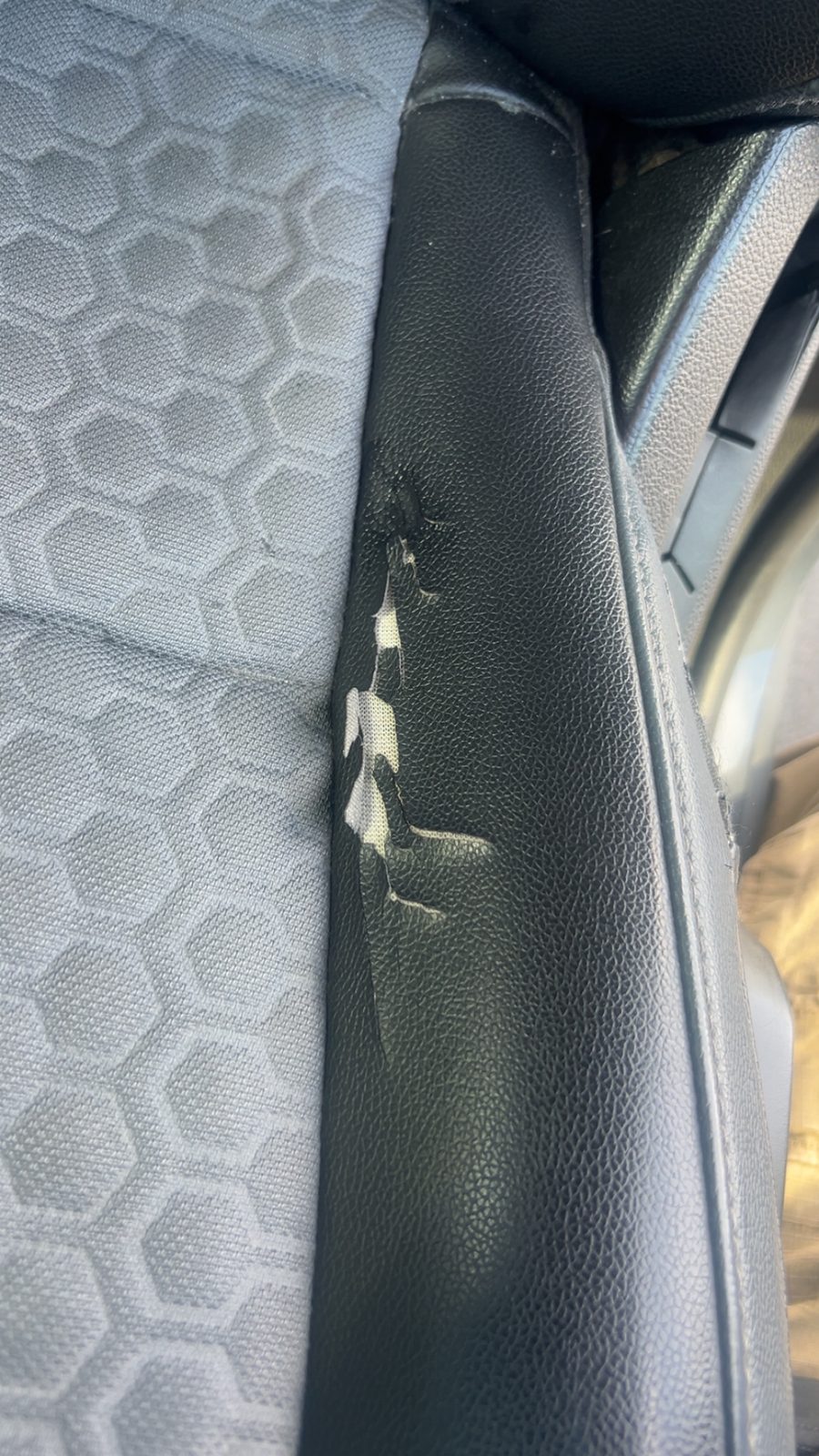 Torn leather bolster before repair